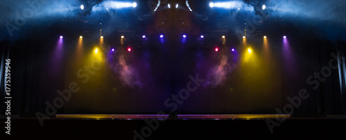 An empty stage of the theater, lit by spotlights and smoke before the performance