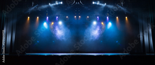 An empty stage of the theater, lit by spotlights and smoke before the performance