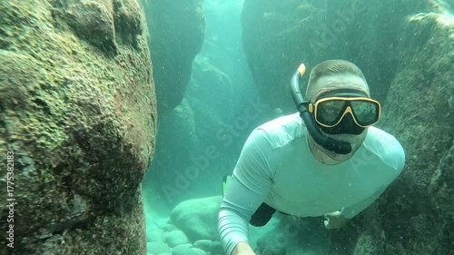 A couple vacations in the tropics. The man dives and snorkels while relaxing in the tropical sea.