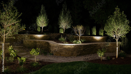 Illuminated garden landscape at night with trees and stone retaining walls