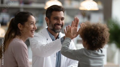 Trust and Care: A heartwarming moment unfolds as a doctor shares a high-five with a child, while a parent witnesses with happiness, showing medical trust and mutual care. 