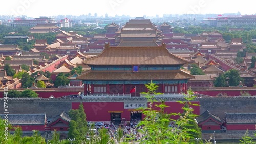 Aerial view of Forbidden City imperial palace with traditional Chinese architecture, golden roofs, ancient buildings surrounded by lush greenery in Beijing, China.