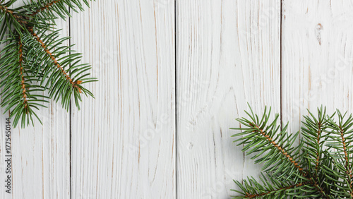 Pine tree branches on white wooden background.