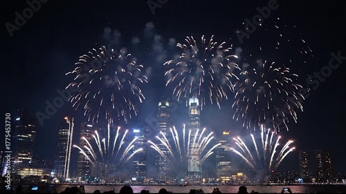 Spectacular fireworks display illuminates city skyline at night, celebrating a festive occasion.