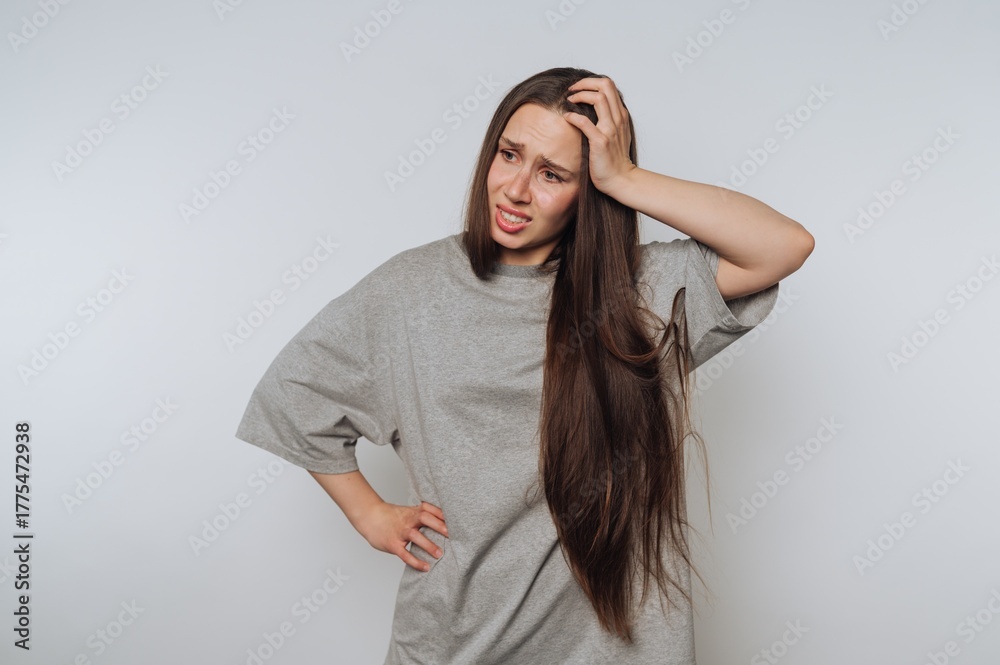 Fototapeta premium Woman with long hair looking confused and scratching her head