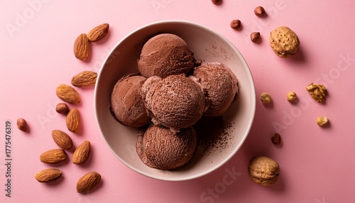 homemade chocolate ice cream with nuts and cocoa powder on a pink background top view