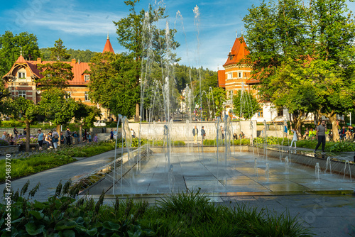 Main square and modern fountain in the Spa Park of Krynica Zdroj, Poland, surrounded by historic resort architecture.