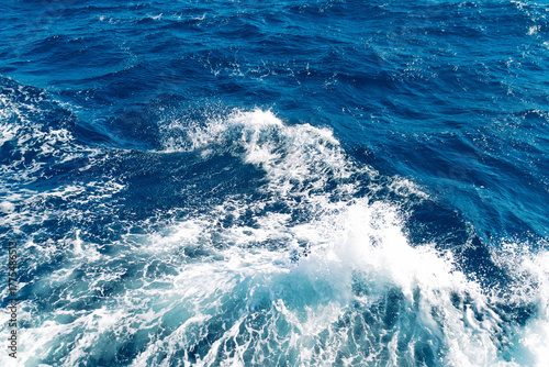 Foto Vibrant ocean waves crashing against blue surface on a sunny day