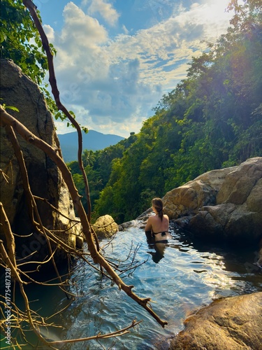 Young Woman Enjoys Sunset View in Natural Jungle Infinity Pool