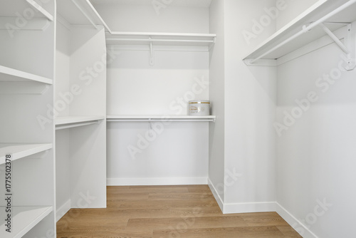 White closet with a wooden floor and shelves