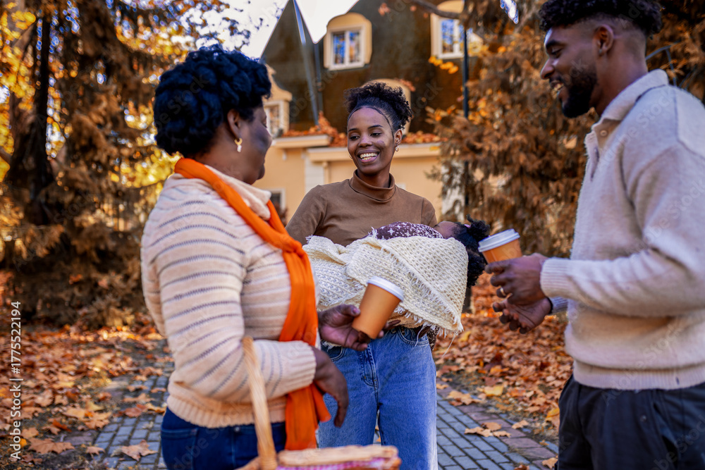 Naklejka premium African American Family Walking to Autumn Picnic with Sleeping Baby