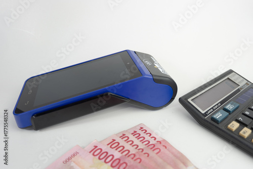 Electronic Data Capture (EDC) machines and calculator with Indonesian money, finance and business concept