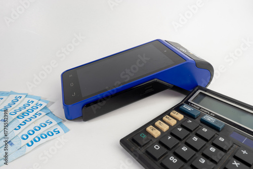 Electronic Data Capture (EDC) machines and calculator with Indonesian money, finance and business concept