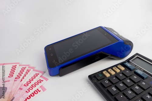 Electronic Data Capture (EDC) machines and calculator with Indonesian money, finance and business concept