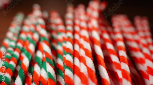Christmas color theme striped pipe cleaners on dark wooden oak table top in warm candle light