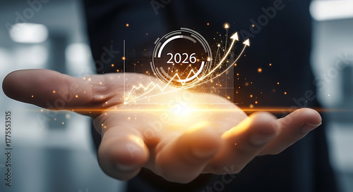 Businessman holding glowing 2026 with growth chart and arrows