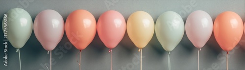 Colorful pastel balloons in a row against a soft gray background celebrating events and joyful moments