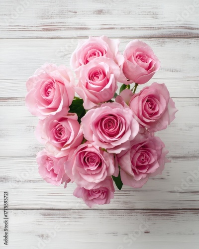 Bouquet of pink roses on a white wooden background from top view, elegant romantic and detailed with soft natural light.