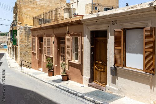Fototapeta Naklejka Na Ścianę i Meble -  A typical small house front in Malta - with wooden door, window shutters and pots