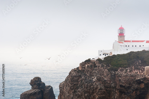 Lighthouse on Cape St. Vincent at foggy sunset in Algarve, Portugal.