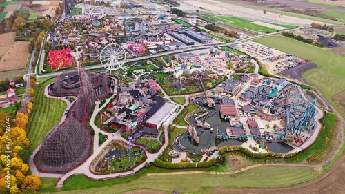 Aerial drone view of Energylandia amusement park in Zator, Poland. Colorful rides, roller-coasters and crowds under sunny weather, high-energy entertainment hub.
