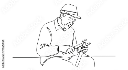 Elderly man whittling wood while sitting at a table indoors  