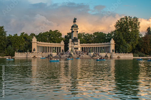 Pond and monument to King Alfonso XII, King ofA pond with people and pleasure boats and a monument to King Alfonso XII, King of Spain, at sunset in Buen Retiro Park in Madrid, Spain. Spain, at sunset 