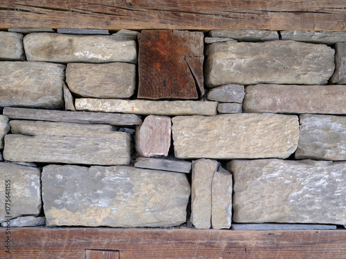 Crop view of a stone wall bordered above and below by wooden beams