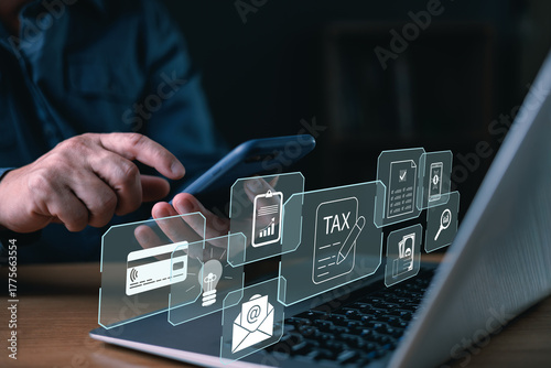 A person using smartphone and laptop with digital tax and finance icons, representing online tax payment, financial management, e-invoice, and digital accounting technology.