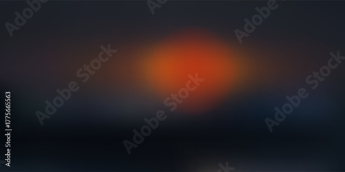 Out of focus sun setting over the ocean glowing orange with dark blue background