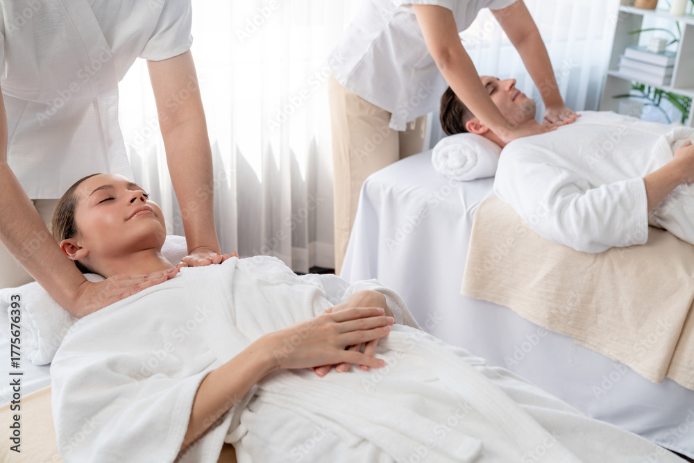 Obraz premium Caucasian couple customer enjoying relaxing anti-stress spa massage and pampering with beauty skin recreation leisure in day light ambient salon spa at luxury resort or hotel. Quiescent