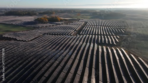 Huge solar farm in countryside, aerial drone view, solar panels, early morning golden hour