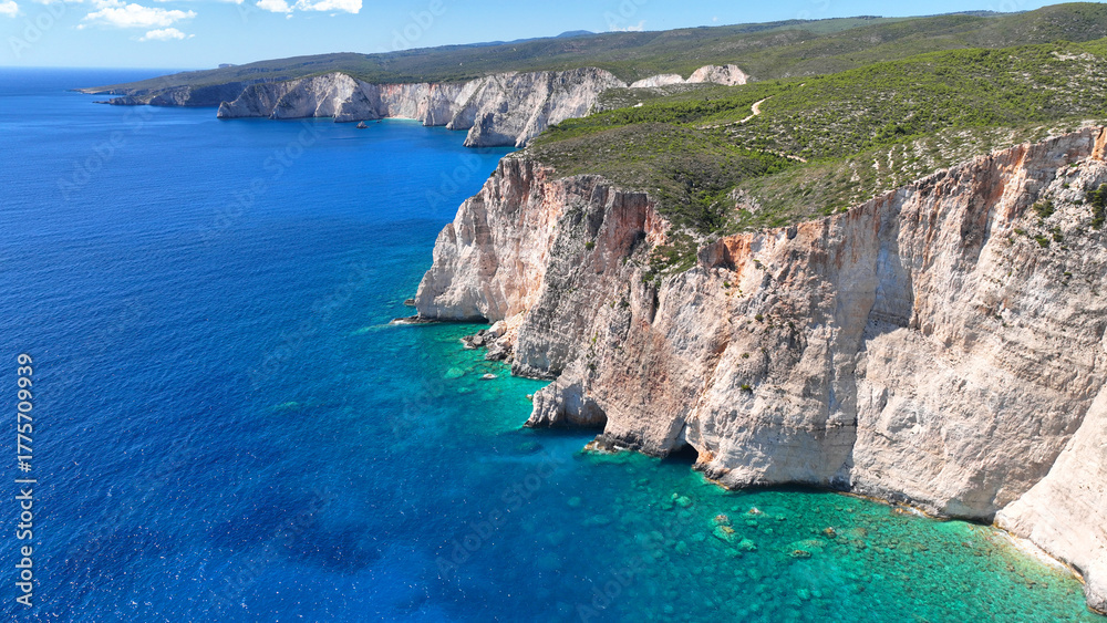 Fototapeta premium Aerial drone photo of scenic paradise bay with white rocky seascape forming small caves surrounded by limestone trees visited by small boats and yachts in tropical exotic island destination