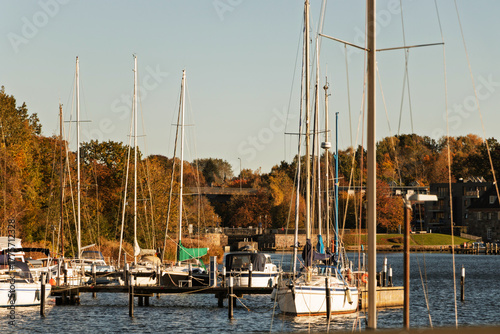 Fototapeta Naklejka Na Ścianę i Meble -  A harbour where white yachts are moored. The Baltic Sea. Blue water. A warm autumn sky.
