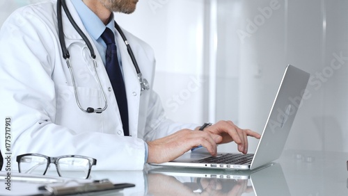 Doctor hands typing on laptop keyboard, offering online remote consultation or digital medical assistance, focused on treatment. Medicine, healthcare and science concept