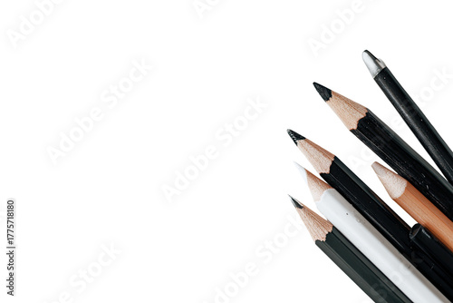 Assorted pencils and pens clustered in a corner against a black background