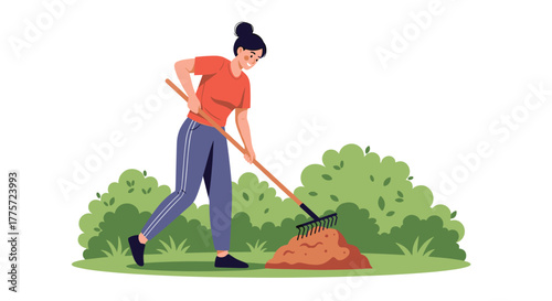 Diligent woman actively raking a pile of leaves and organic matter in a green garden, illustrating seasonal yard work and composting.