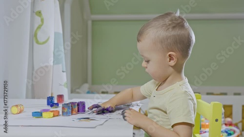 Little toddler boy painting with his hands