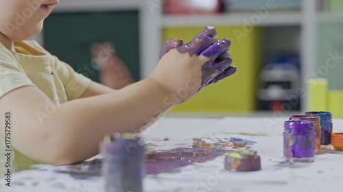 Child with painted hands enjoying creative finger painting