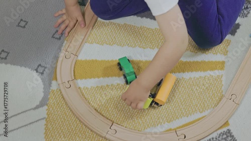 Toddler boy playing with wooden toy train set