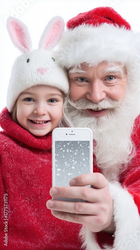 Caucasian elderly male santa and caucasian child enjoying festive selfie in winter attire
