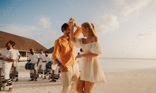 Newlyweds dancing on a tropical beach during a luxury vacation