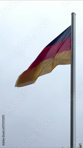 German flag waving in cloudy sky during peaceful day in city