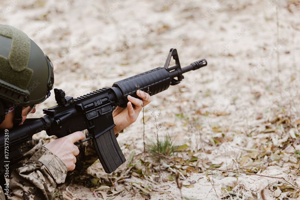 Fototapeta premium Soldier in tactical gear aims a rifle.
