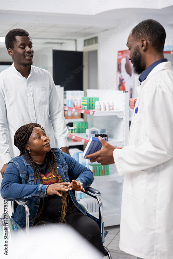 Obraz premium Pharmacist counseling a customer with disability on treatment options, discussing about medication dosage to support patient health. Professional medical staff showing drugstore pills.