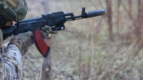 Soldier fires a suppressed tactical rifle. Concept for modern warfare, special forces, and security operations.