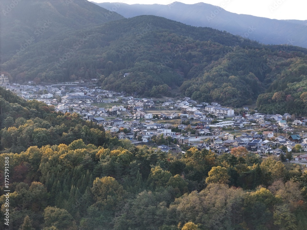 Fototapeta premium A mountain range with a town in the valley below. The town is mostly white and has a peaceful, serene atmosphere