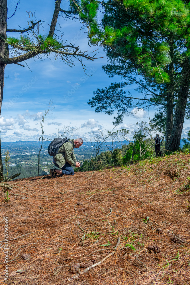 Naklejka premium Adventurous man with a backpack looking in awe at nature during a mountain hike.