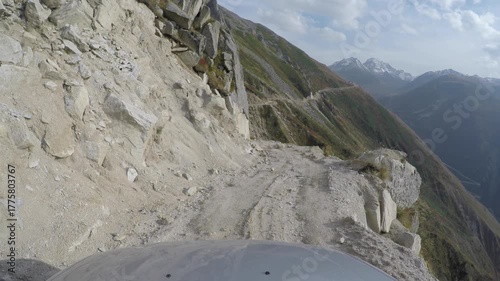 Aerial shot of a 4x4 SUV on a dangerous, narrow Himalayan mountain road cliff edge. The vehicle navigates the perilous, high elevation terrain, creating a thrilling adventure scene near the abyss.