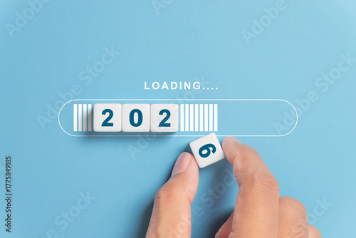 Hand putting dice for loading progress from 2025 to 2026 to countdown merry christmas and happy new year concept.
